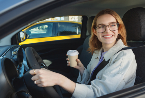 車でコーヒーを飲む女性